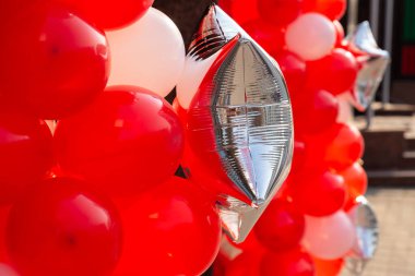 Kırmızı balonlar ve gümüş şeklinde bir balon. Tatiller veya etkinlik sokak dekorasyonu kavramı