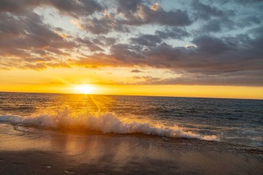 Gün batımında deniz fırtınası. Dalgalar canlı günbatımının önündeki kıyıya altın saatinde Florida 'daki bir plaja geliyor.