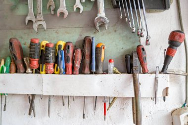 Bir tamircinin el yapımı çekmecesinde asılı duran kullanılmış tornavidaların gizli koleksiyonu.