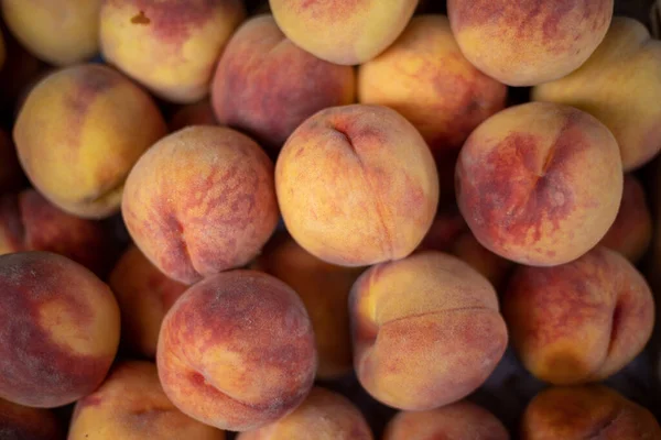 Peach closeup background on a farmers market stand with lots of peaches