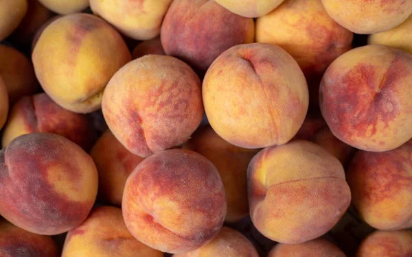 Peach closeup background on a farmers market stand with lots of peaches