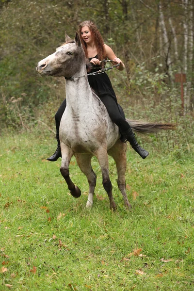 Удивительная девушка с длинными волосами верхом на лошади — стоковое фото
