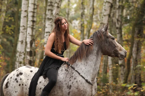 Jovem com cavalo appaloosa no outono — Fotografia de Stock