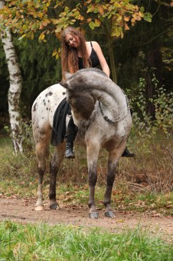 Beautiful girl riding a horse without bridle or saddle clipart
