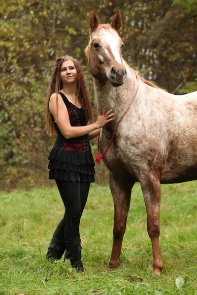 Beautiful girl with nice dress standing next to nice horse — Stock Photo, Image