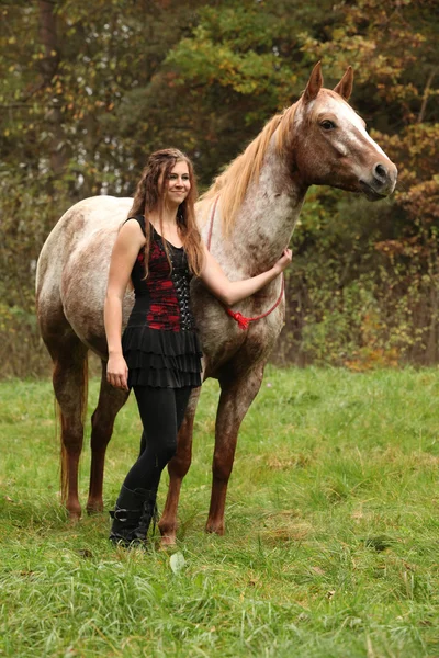 Beautiful girl with nice dress standing next to nice horse — Stock Photo, Image