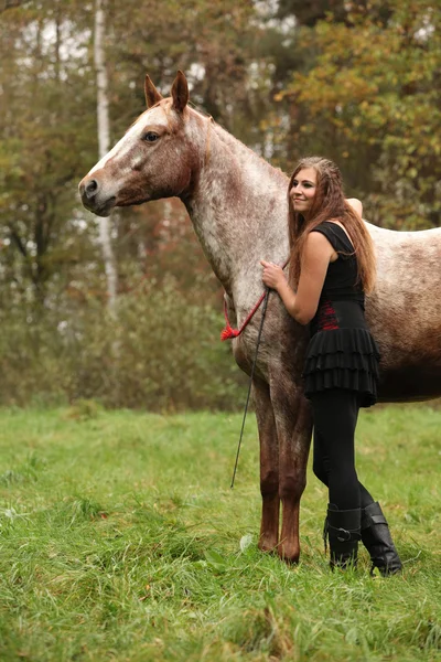 Beautiful girl with nice dress standing next to nice horse — Stock Photo, Image