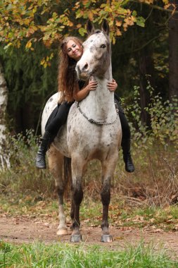Beautiful girl riding a horse without bridle or saddle clipart