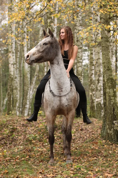 Jovem com cavalo appaloosa no outono — Fotografia de Stock