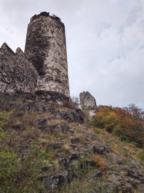 Bezdez, Çek Cumhuriyeti - 2 Ağustos 2018: Çekoslovakya Cumhuriyeti 'nde sonbahar yeşilliklerinin canlı renkleriyle çevrili, bulutlu bir gökyüzüne karşı heybetli kule ayakta duruyor