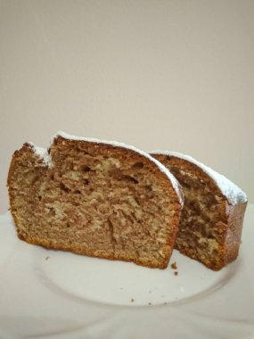 İki dilim taze pişmiş mermer pasta, krema şekeri ile tozlanmış, beyaz bir tabağa oturmuş, fotokopi alanının tadını çıkarmaya hazır.