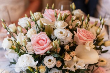 Güzel pembe ve beyaz güller, lisianthus ve kalla zambakları düğün resepsiyonu için göz kamaştırıcı bir süs oluşturuyorlar. Kutlamaya biraz zarafet ve romantizm katıyorlar.