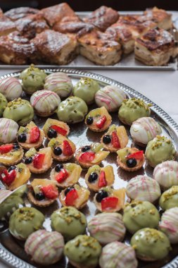 Zarif gümüş tepside rengarenk meyveli turtalar ve şam fıstığı aromalı tatlılar sergileniyor. Düğün kutlamalarına biraz da şirinlik ve incelik katılıyor.