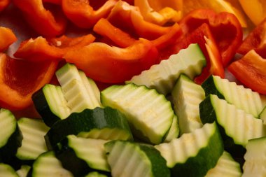 Bir yüzeye dizilmiş kabak ve dolma biber dilimleri pişirmeye hazır taze ve sağlıklı malzemeler sunar. Yüksek kalite fotoğraf