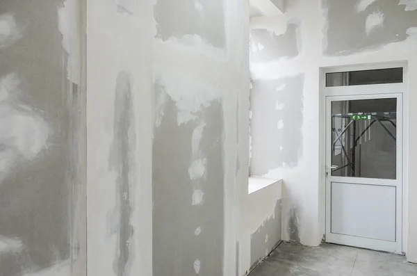 Nedokončené stěny s sádrovce a bílé dveře — Stock fotografie