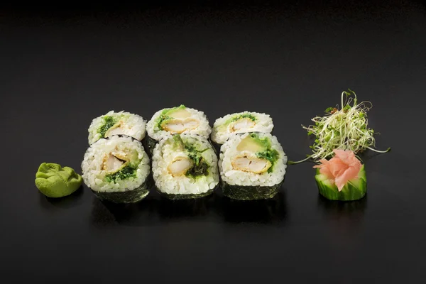 Deliciosos rollos de sushi japoneses decorados con ensalada de algas marinas y — Foto de Stock