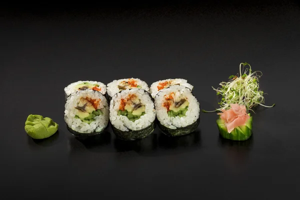 Rollos de sushi japonés frescos decorados con ensalada de algas marinas y Imágenes de stock libres de derechos
