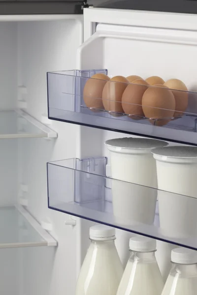 Opened refrigerator full of eggs and milk — Stock Photo, Image