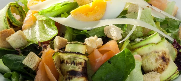 Close-up of salad with smoked salmon and zucchini rolls — Stock Photo, Image