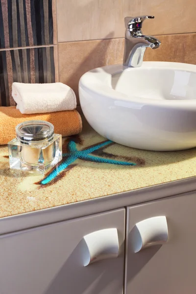 detail of modern bathroom in orange color with round white sink