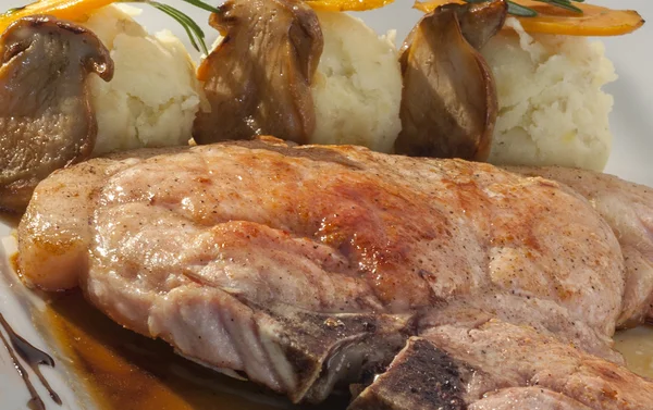 Roasted pork steak garnished with mashed potatoes and mushrooms — Stock Photo, Image