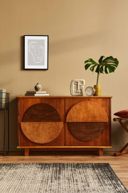 Tasarım ahşap klozet, tabure, vazoda tropikal yaprak, eşsiz dekorasyon, halı, poster çerçevesi ve zarif kişisel aksesuarlar. Klasik evdeki modern oturma odası.