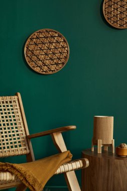 Modern evin iç dekorasyonu, tasarım rattan koltuk, kahverengi ahşap sehpa, kitap, rattan dekorasyon, poster çerçevesi, ev dekorunda perosnal aksesuarlar..