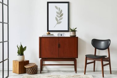 Ahşap retro klozet, sandalye, bitki, rattan dekorasyon, küp ve zarif kişisel aksesuarları olan şık bir oturma odası tasarımı. Beyaz duvara poster çerçevesi yap. Şablon.