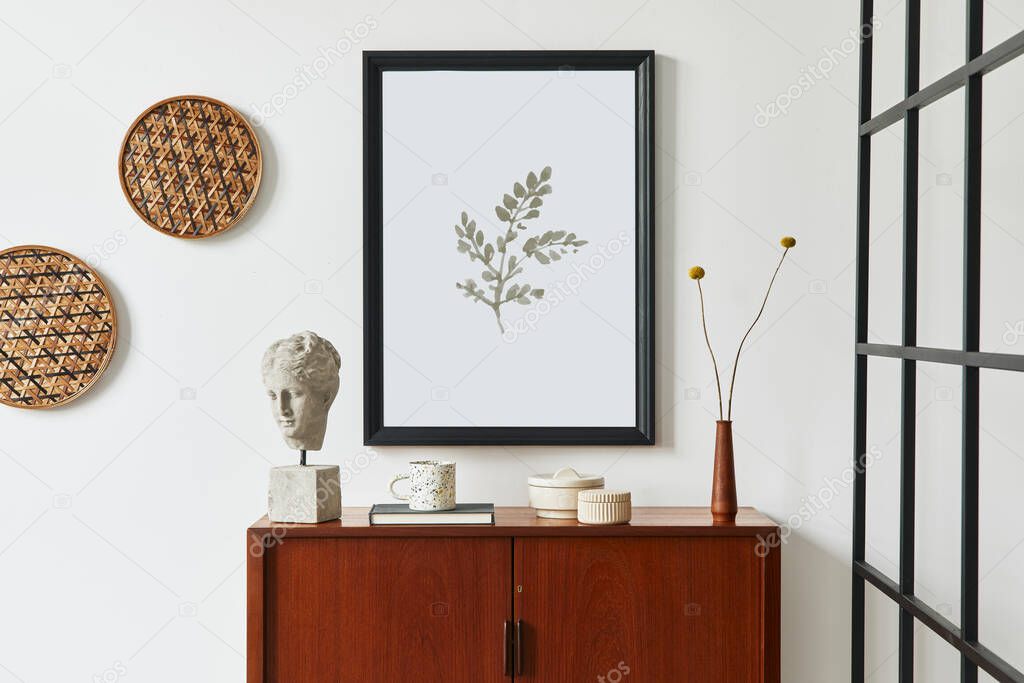 Retro modern compositon of living room interior with design teak commode, black mock up poster frame, book, dried flower in vase, rattan decoration, white wall and personal accessories. Template.