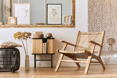 Şık rattan koltuklar, tasarım mobilyaları, kurutulmuş çiçekler, poster çerçeveleri, ahşap döşemeler, dekorasyon ve zarif kişisel aksesuarlarla eşsiz bir oturma odası. Modern ev. Şablon.