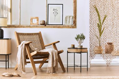 Şık rattan koltuklar, tasarım mobilyaları, kurutulmuş çiçekler, poster çerçeveleri, ahşap döşemeler, dekorasyon ve zarif kişisel aksesuarlarla eşsiz bir oturma odası. Modern ev. Şablon.