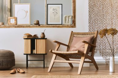 Şık rattan koltuklar, tasarım mobilyaları, kurutulmuş çiçekler, poster çerçeveleri, ahşap döşemeler, dekorasyon ve zarif kişisel aksesuarlarla eşsiz bir oturma odası. Modern ev. Şablon.