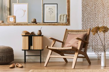 Şık rattan koltuklar, tasarım mobilyaları, kurutulmuş çiçekler, poster çerçeveleri, ahşap döşemeler, dekorasyon ve zarif kişisel aksesuarlarla eşsiz bir oturma odası. Modern ev. Şablon.