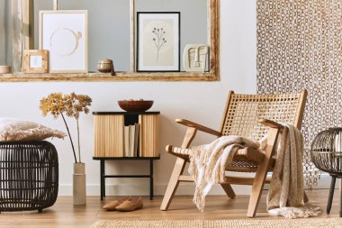 Şık rattan koltuklar, tasarım mobilyaları, kurutulmuş çiçekler, poster çerçeveleri, ahşap döşemeler, dekorasyon ve zarif kişisel aksesuarlarla eşsiz bir oturma odası. Modern ev. Şablon.