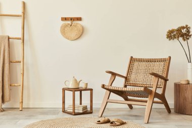 Ahşap koltuklu, kahve masalı, mobilyalı, rattan dekorasyonlu, kurumuş çiçekli ve zarif kişisel aksesuarlı bir oturma odası tasarımı. Uzay beyaz duvarını kopyala. Şablon.