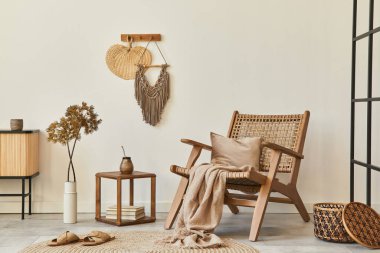 Ahşap koltuklu, kahve masalı, mobilyalı, rattan dekorasyonlu, kurumuş çiçekli ve zarif kişisel aksesuarlı bir oturma odası tasarımı. Uzay beyaz duvarını kopyala. Şablon.