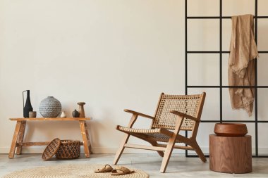 Ahşap koltuğu, kahve masası, bank, rattan dekorasyonu, halısı ve zarif kişisel aksesuarları olan şık bir oturma odası tasarımı. Uzay beyaz duvarını kopyala. Şablon.