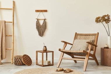 Ahşap koltuklu, kahve masalı, mobilyalı, rattan dekorasyonlu, kurumuş çiçekli ve zarif kişisel aksesuarlı bir oturma odası tasarımı. Uzay beyaz duvarını kopyala. Şablon.