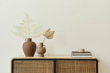 Modern İskandinav ev dekorasyonu ahşap klozet, seramik vazolarda kurutulmuş yapraklar ve şık ev dekorunda kişisel aksesuarlar. Şablon. Uzayı kopyala Beyaz duvarlar.