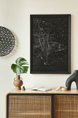 Oturma odasının içerisindeki minimalist kompozisyonda siyah poster haritası, ahşap tuvalet, siyah yuvarlak dekorasyon, vazolarda yaprak ve zarif kişisel aksesuarlar. Şablon.
