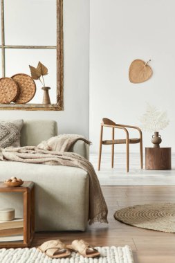 Tasarım bej kanepesi, ahşap tabure, kitap, halı, sandalye, dekorasyon, mobilya ve şık kişisel aksesuarları olan şık bir oturma odası kompozisyonu. Modern ev dekorasyonu. Açık alan. Şablon.