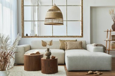 Modüler kanepe, mobilya, ahşap sehpa, ahşap dekorasyon, kolye lambası, yastık, kurumuş çiçekler ve modern ev dekorunda zarif aksesuarları olan bir oturma odası..