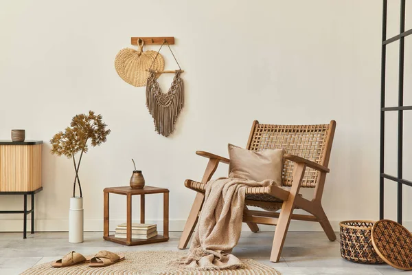 Ahşap koltuklu, kahve masalı, mobilyalı, rattan dekorasyonlu, kurumuş çiçekli ve zarif kişisel aksesuarlı bir oturma odası tasarımı. Uzay beyaz duvarını kopyala. Şablon.