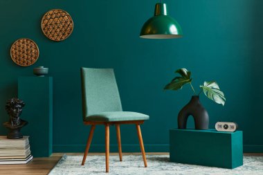 Tasarım koltuğu, bej vazoda tropikal yaprak, saat, retro halı, dekorasyon, kolye lambası ve modern klasik ev dekorasyonu aksesuarları ile oturma odası konsepti..