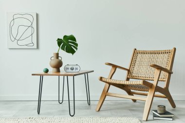 Minimalist oturma odası konsepti rattan koltuk, ceviz sehpası, vazoda tropikal yaprak, saat, boyalar, kitaplar ve şık ev dekorları ile kişisel aksesuarlar. Şablon.