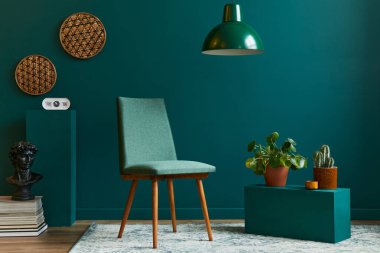 Tasarım koltuğu, bej vazoda tropikal yaprak, saat, retro halı, dekorasyon, kolye lambası ve modern klasik ev dekorasyonu aksesuarları ile oturma odası konsepti..