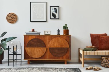 Şık İskandinav kompozisyonu tasarım klozeti, siyah poster çerçeveleri, rattan puf, kanepe, kitap, dekorasyon ve modern ev dekorasyonu kişisel aksesuarlar.