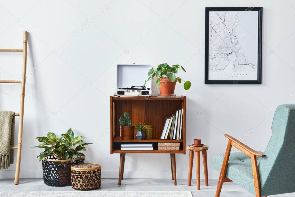 Modern retro composition of living room interior with design wooden cabinet, stylish armchair, mock up poster map, plants, vinyl recorder, books and personal accessories in home decor. Template.