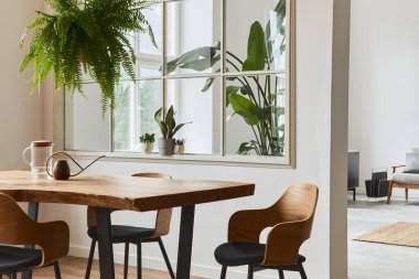 Yemek odasının dekorasyonu ahşap masa, sandalyeler, bitkiler, kadife kanepe, poster haritası ve modern ev dekorunda zarif aksesuarları olan şık ve rahat bir iç mekanı. Şablon.