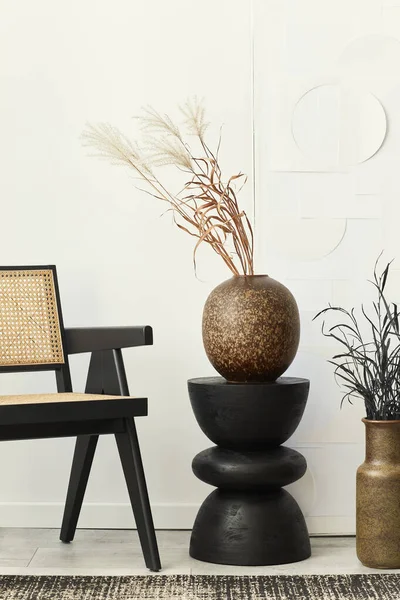 白色客厅室内装饰风格别致 有设计椅子 黑色木制凳子 花瓶中的干花 地毯装饰和墙上的艺术绘画 — 图库照片